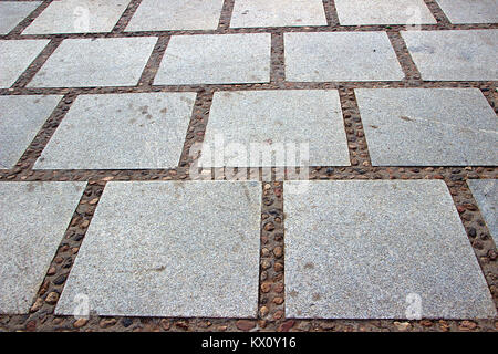 Layout of dressed rectangular grey, granular, granite stone slabs on pavement Stock Photo
