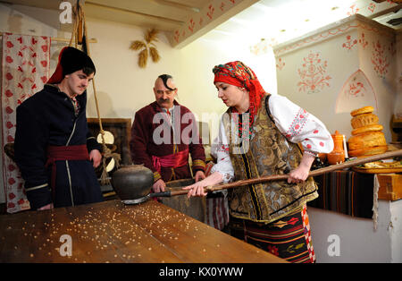 People in Ukrainian national costumes cooking traditional dish kutia on Christmas Eve. January 4, 2018. Kyiv, Ukraine Stock Photo