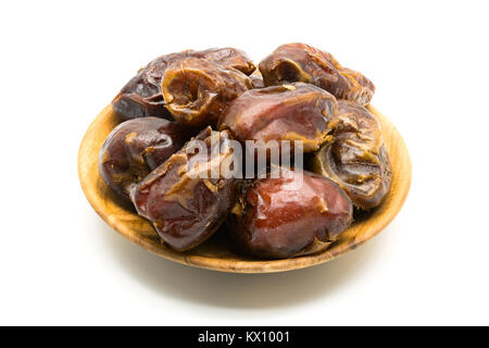 Dried dates fruit in wooden plate on white background Stock Photo