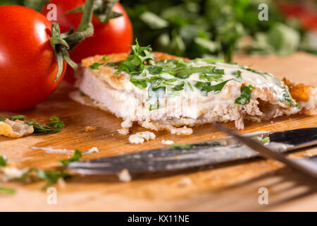 Pork schnitzel with white sauce and parsley on wooden cutting board Stock Photo