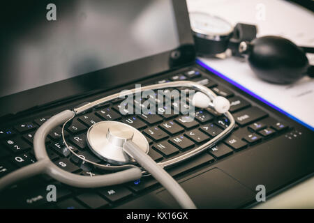 Stethoscope and a black laptop on a desk Stock Photo