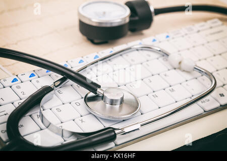 Stethoscope and a white keyboard on a desk Stock Photo