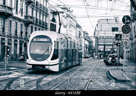 A tram runs along a Milan street. The public transport company in Milan (ATM) is very efficient, on top of Italian standards. Stock Photo