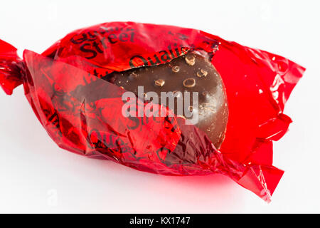 Quality Street chocolate by Nestle – strawberry delight chocolate, red Quality Street, with wrapper undone to show chocolate set on white background Stock Photo