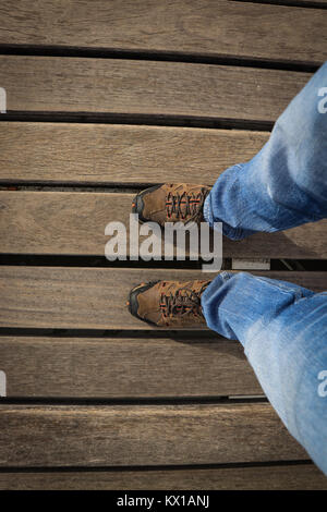 Top view from Young man with sneakers and jeans in a woods floor. Adventure shoes. Stock Photo