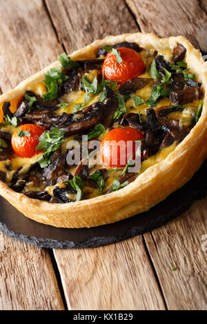 Open mushroom pie with cheese, parsley and tomatoes close-up on the table. vertical Stock Photo