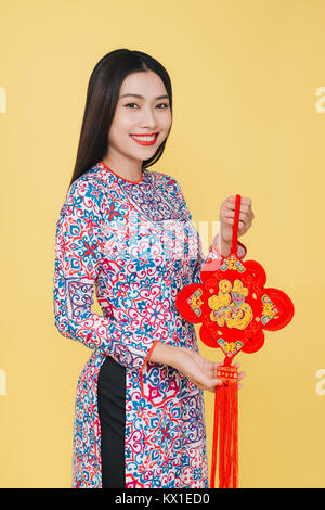 Attractive asian woman wearing traditional costume, isolated on yellow background. Text mean Happiness. Stock Photo