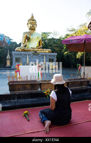 Thai woman respect praying and visit Golden big buddha statue name Phra Mongkol Ming Muang at Buddha garden on September 18, 2017 in Amnat Charoen, Th Stock Photo