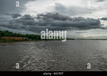 A patch of low dark thick clouds floating over the Mekong river, river bank. Rainy clouds during Monsoon season in Phnom Penh, Cambodia, SE Asia Stock Photo