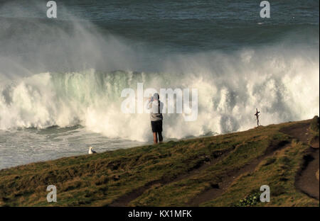 Fistral Beach, Newquay, UK. 6th Jan, 2018. UK Weather. Sunlit the Legendary Cribbar point wave breaks for a spectator. Fistral Beach, Newquay, UK 6th, January, 2018 Credit: Robert Taylor/Alamy Live News Stock Photo