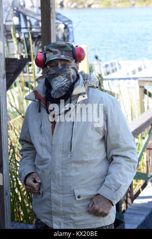 WESTON, FL - JANUARY 05: (EXCLUSIVE COVERAGE) Brutal cold sends shivers through Northeast after 'bomb cyclone. Florida Fish and Wildlife Conservation Commission officials said iguanas can become immobilized or sluggish when temperatures hit between 40 and 50 degrees. Iguanas all over the state are falling out of trees after becoming to cold. Seen here tourist and guides dress warm for the airboat ride as  employee Tim is talking care of "IGGY" the baby Iguana by wrapping him in a blanket and even putting gloves on him to keep him warm at the SawGrass Recreation Park located in Everglades Natio Stock Photo
