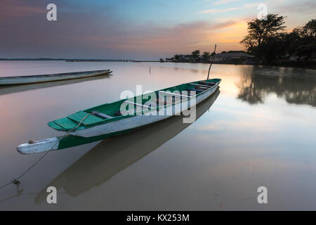 Landscape view of moored boat on calm river at sunrise, Tendaba Camp, The Gambia in November. Stock Photo