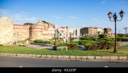 Nesebar, Bulgaria - July 20, 2014: Tourists walk near ruined stone walls around Nesebar historic town Stock Photo