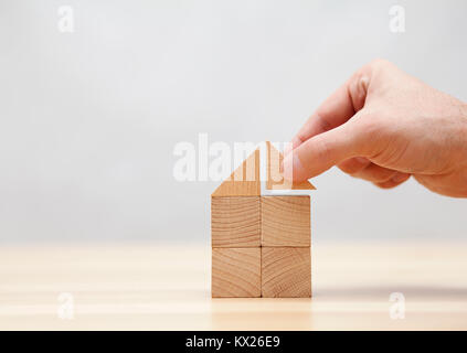 Hand building house with wooden blocks Stock Photo
