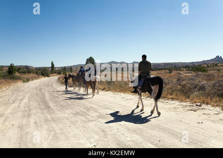 Cappadocia, Turkey, September 3, 2017: People riding horses on the road. Stock Photo