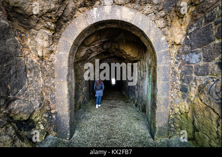 woman walking through a dark tunnel Stock Photo