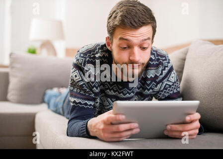 Surprised Young Man with Tablet Computer at the Home Stock Photo