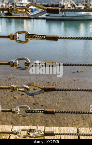 Steel cables and stainless steel connections form a fence in Newport Oregon Stock Photo