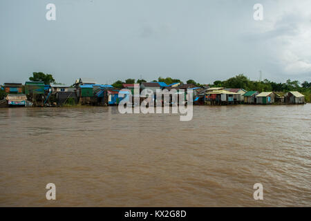A small shanty town, squatter settlement of poor houses of wood and corrugated metal sheets, shanties shacks next to Mekong River, Phnom Penh Cambodia Stock Photo