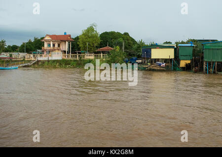 A beautiful rich house next to a slum shanty town of corrugated metal shacks on the river bank of the Mekong, close to Phnom PEnh, Cambodia, Asia Stock Photo