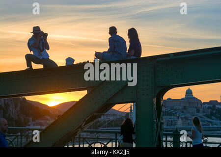 Young couple and photographer against sunset in Budapest Stock Photo