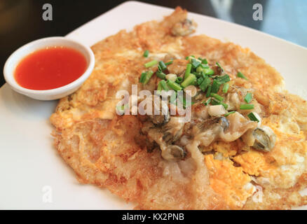 Fried oysters crispy omelette with sweet and spicy dipping sauce severed on white plate Stock Photo