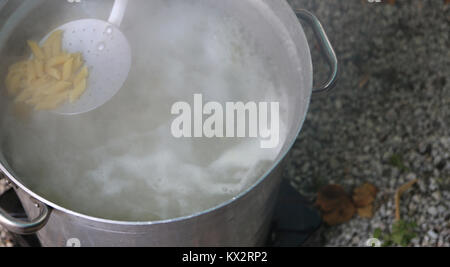 big pot with pasta in the kitchen camp Stock Photo