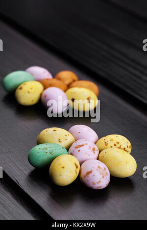 Mini Easter eggs on a modern dark wooden floor. Flower pattern with copy space. Stock Photo