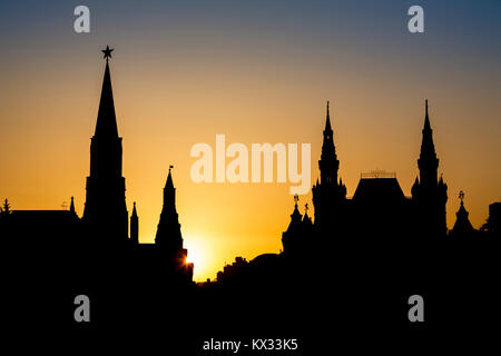 View of the Nikolskaya Tower (St Nicholas Tower) in the Kremlin Wall and the State Historical Museum, Red Square, Moscow, Russia silhouetted at sunset Stock Photo