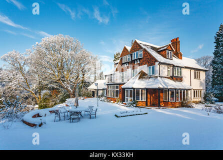 Prime residential property: Large detached Tarrant house and garden, Surrey, SE England, with a thick covering of snow after heavy snowfall in winter Stock Photo