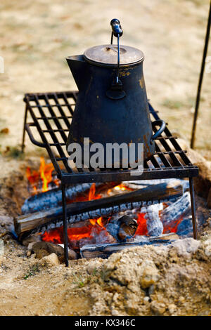 Ancient tea kettle on campfire. Stock Photo