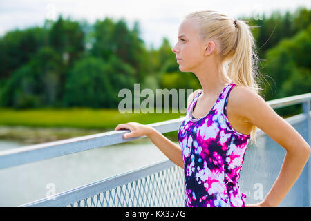 Thoughtful young woman rests after training Stock Photo