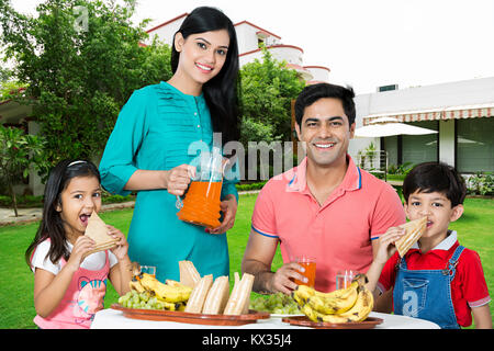 Happy Family parents and Children eating breakfast together Courtyard at-home Stock Photo