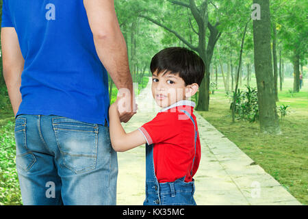 Father Holding Hand Kid Son In Park Walkway Walking Stock Photo