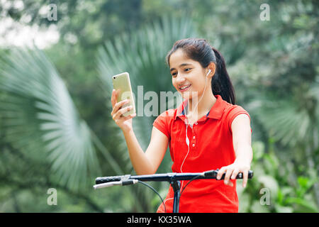 Young Girl Hearing Music Ride Cycle Garden Stock Photo