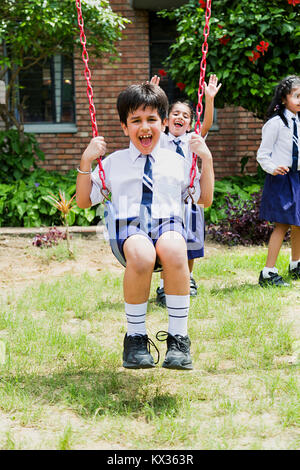 Indian School Students Boy Swing Jhulla Having Fun In Park Stock Photo