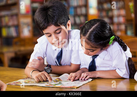 2 Indian School Kids Friend Students Reading Book Studying In Library Stock Photo