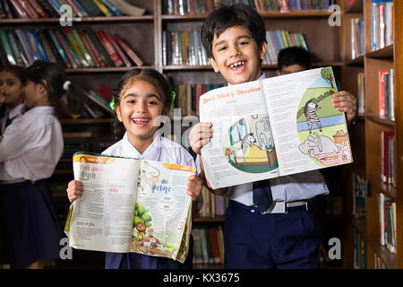 Happy 2 Indian School Little Friend Students Showing Book In Library Stock Photo