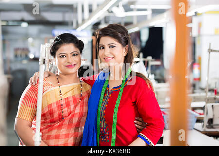 2 ladies Workers Colleague Tailor s Showing Cellphone In Sewing Workshop Stock Photo