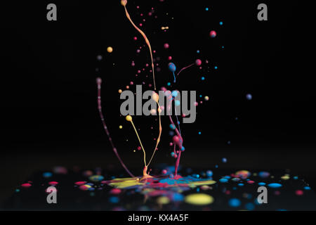 Splash of colorful liquid paint on a black background paint splash on black background Stock Photo
