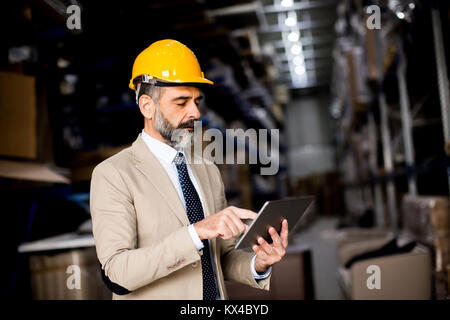 Portrait of middle-aged businessman with digital tablet in factory Stock Photo