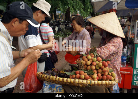 People and fruit vendor on the street in Hanoi, Vietnam Stock Photo