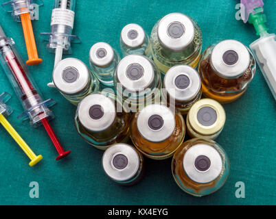 Vials of different size next to syringes at a hospital table, conceptual image Stock Photo