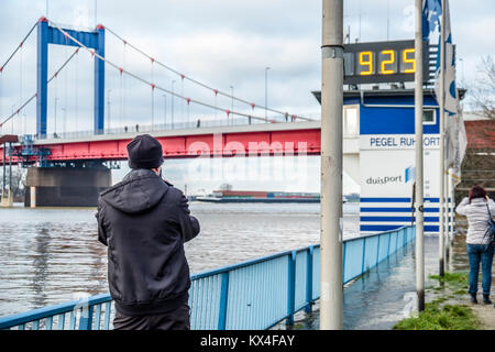 DUISBURG / GERMANY - JANUARY 08 2017 : Tourist observing the the river Rhine flooding the promenade in Ruhrort Stock Photo