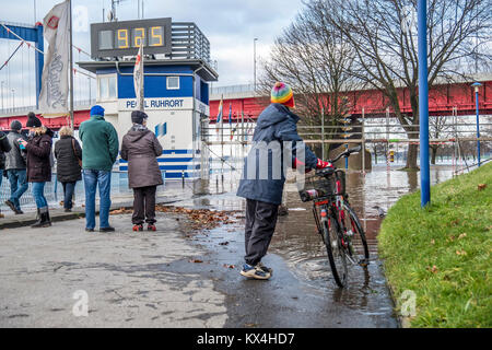 DUISBURG / GERMANY - JANUARY 08 2017 : Lady surprised by the river Rhine flooding the promenade in Ruhrort Stock Photo
