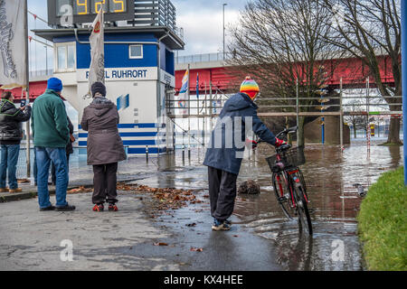DUISBURG / GERMANY - JANUARY 08 2017 : Lady surprised by the river Rhine flooding the promenade in Ruhrort Stock Photo