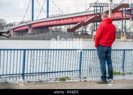 DUISBURG / GERMANY - JANUARY 08 2017 : Tourist observing the the river Rhine flooding the promenade in Ruhrort Stock Photo