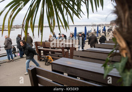 Duesseldorf, Germany. 7th Jan, 2018. Helpers carry away the outdoor furniture which is threatened by flooding on the banks of the river Rhine during high water levels in Duesseldorf, Germany, 7 January 2018. Credit: Bernd Thissen/dpa/Alamy Live News Stock Photo