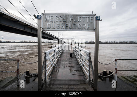 Duesseldorf, Germany. 7th Jan, 2018. A woman standing on a jetty of the 'Weisse Flotte' excursion boats and takes a photo of the river Rhine during high water levels in Duesseldorf, Germany, 7 January 2018. Credit: Bernd Thissen/dpa/Alamy Live News Stock Photo