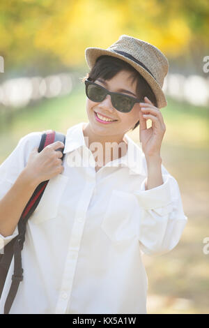 portrait of younger asian woman wearing sun glassess toothy smiling face Stock Photo